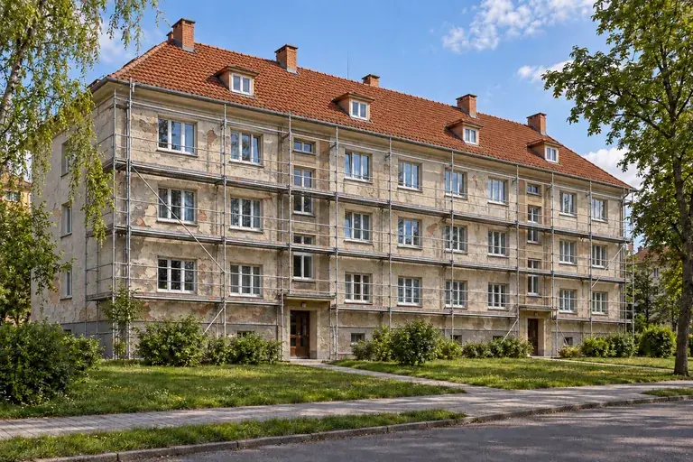 Stejný ilustrační bytový dům před renovací fasády, s lešením